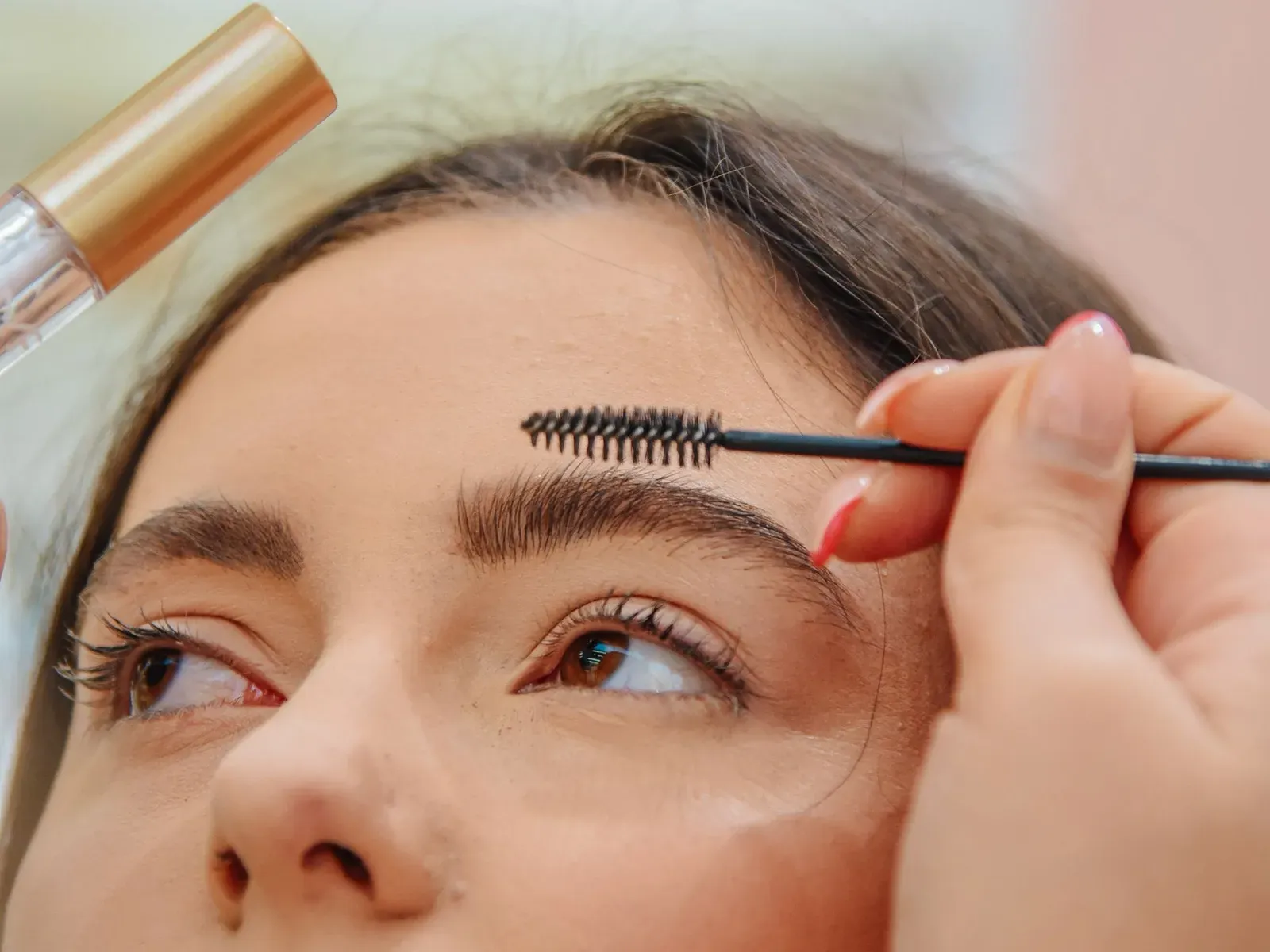 Esthetician brushing tint through a client's brows