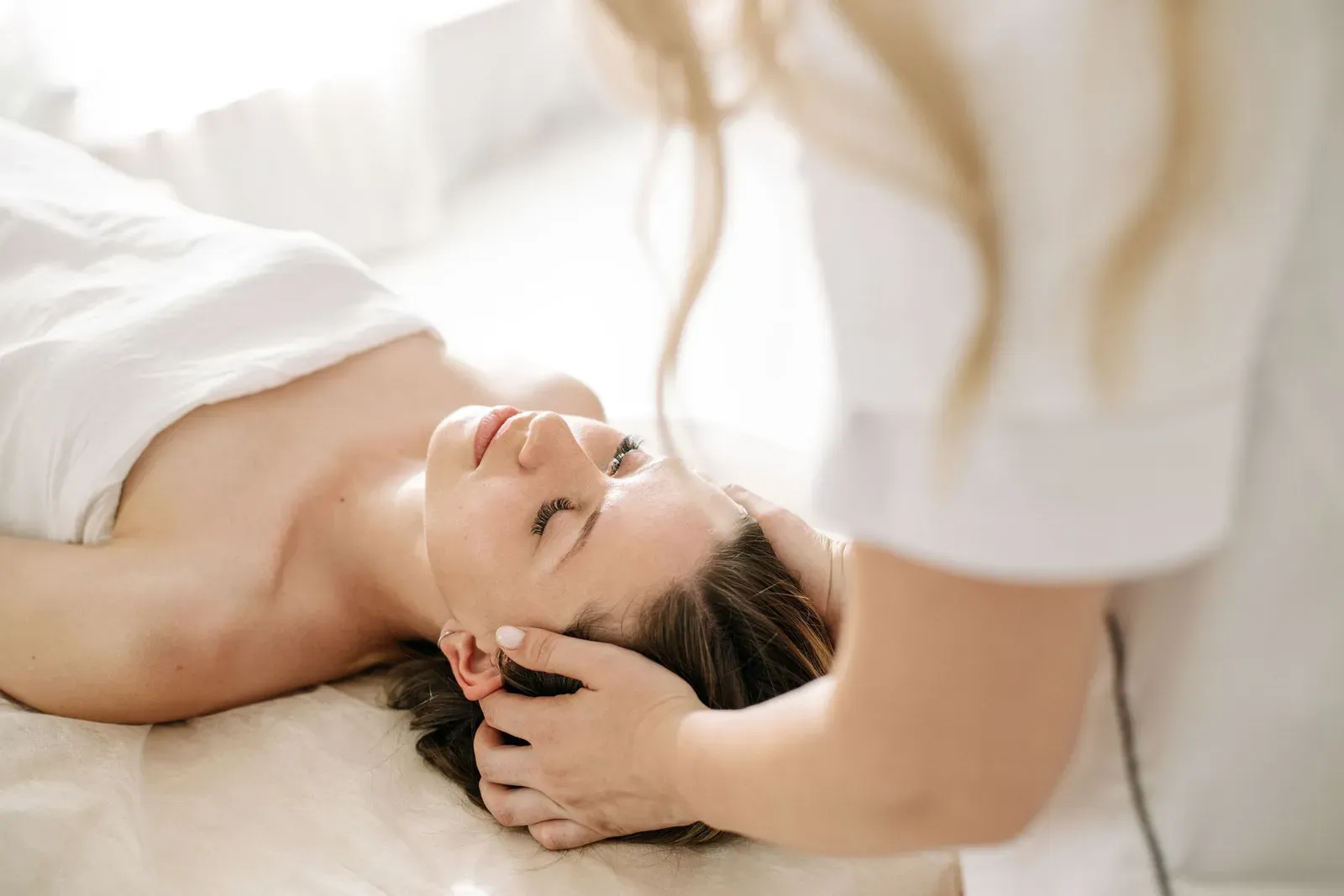 Client reclining for a scalp massage during a head spa treatment