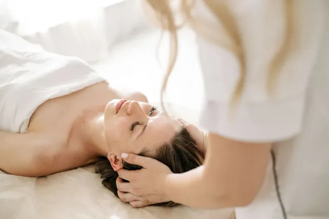 Client reclining for a scalp massage during a head spa treatment