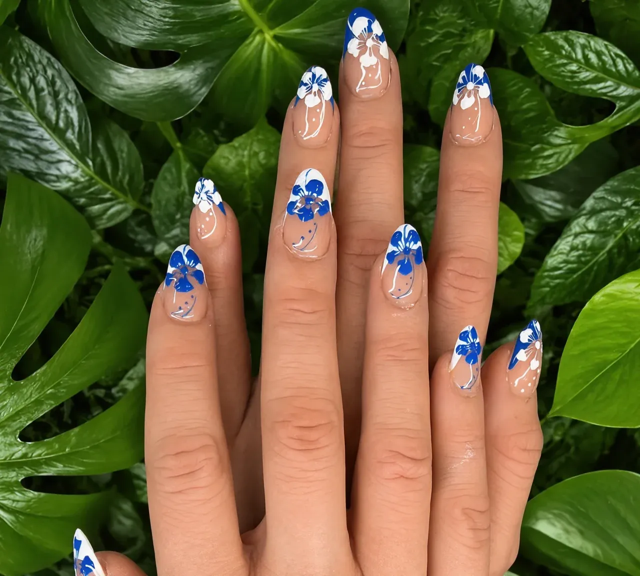Almond nails with hand-painted blue and white hibiscus flowers