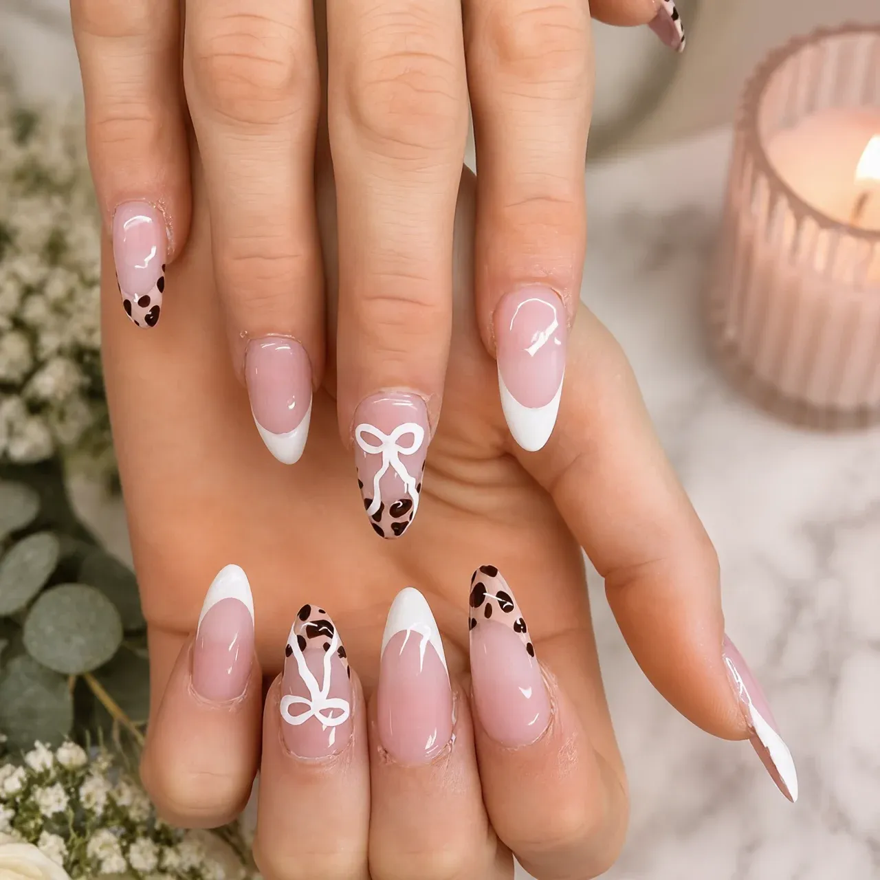 Almond nails with leopard print tips and hand-painted white bows