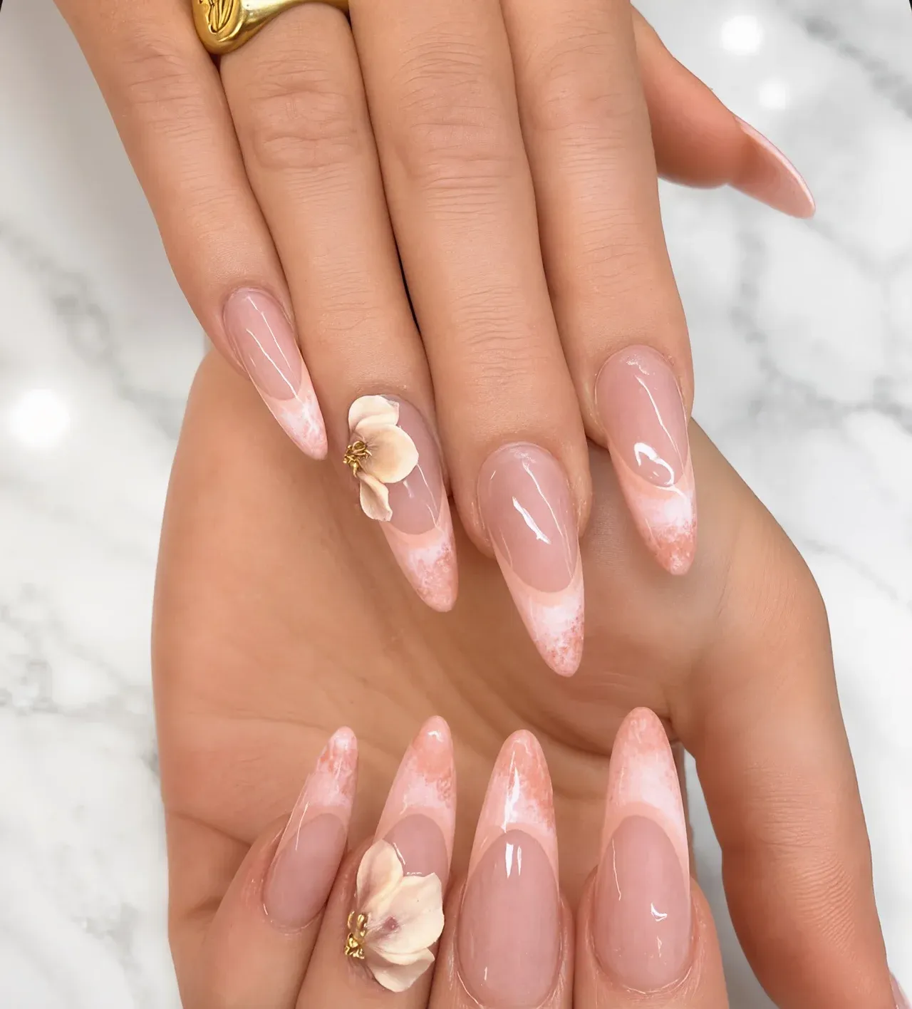 Nude nails with soft marble tips and a hand-sculpted 3D flower
