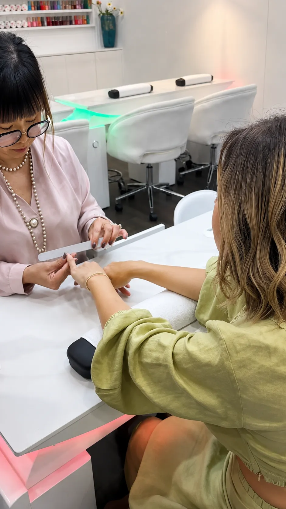 Manicurist filing a client's nails at City Nails & Beauty